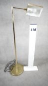 A vintage solid brass swing arm floor lamp with triangular shade, painted white interior and