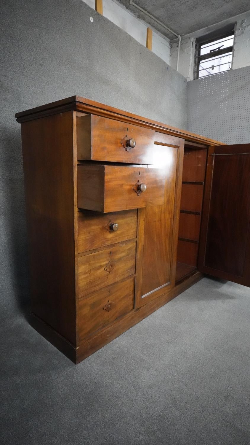 An mid 19th century mahogany linen cupboard with central panel doors flanked by two banks of four - Image 6 of 14