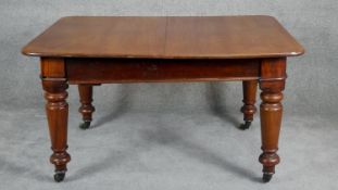 A mid Victorian mahogany extending dining table, the moulded rounded rectangular top with two