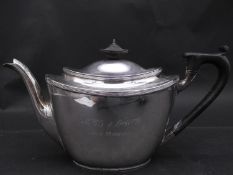An Art Deco silver teapot. The tea pot with an engraved description and hallmarked: TB&S for