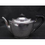 An Art Deco silver teapot. The tea pot with an engraved description and hallmarked: TB&S for