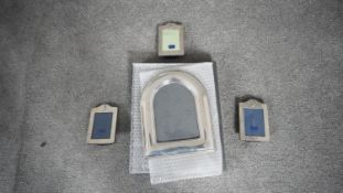 A collection of four sterling silver picture frames. Three F&W small rectangular silver photo frames