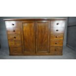 An mid 19th century mahogany linen cupboard with central panel doors flanked by two banks of four