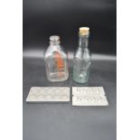 Two vintage milk bottles and two French metal chocolate moulds impressed with maker's marks. H.30