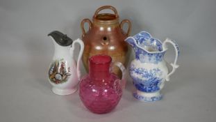 A Victorian cranberry glass jug, a stoneware flagon and two other milk jugs. H.34cm (Tallest)
