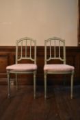 A pair of 19th century Louis XVI style painted salon chairs with carved rosebud top rails above