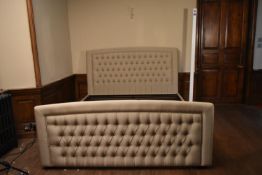 A double bedstead in deep buttoned upholstery. H.128 W.187 L.230cm (to take a super king size, 6ft