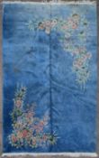 A large Chinese deep pile woollen rug with profuse floral sprays on a sapphire ground. L.430 W.303cm
