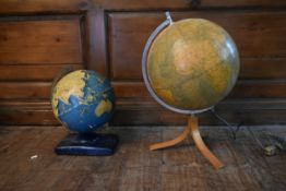 A vintage German light up globe on tripod stand along with a 1950's vintage globe on metal base. H.