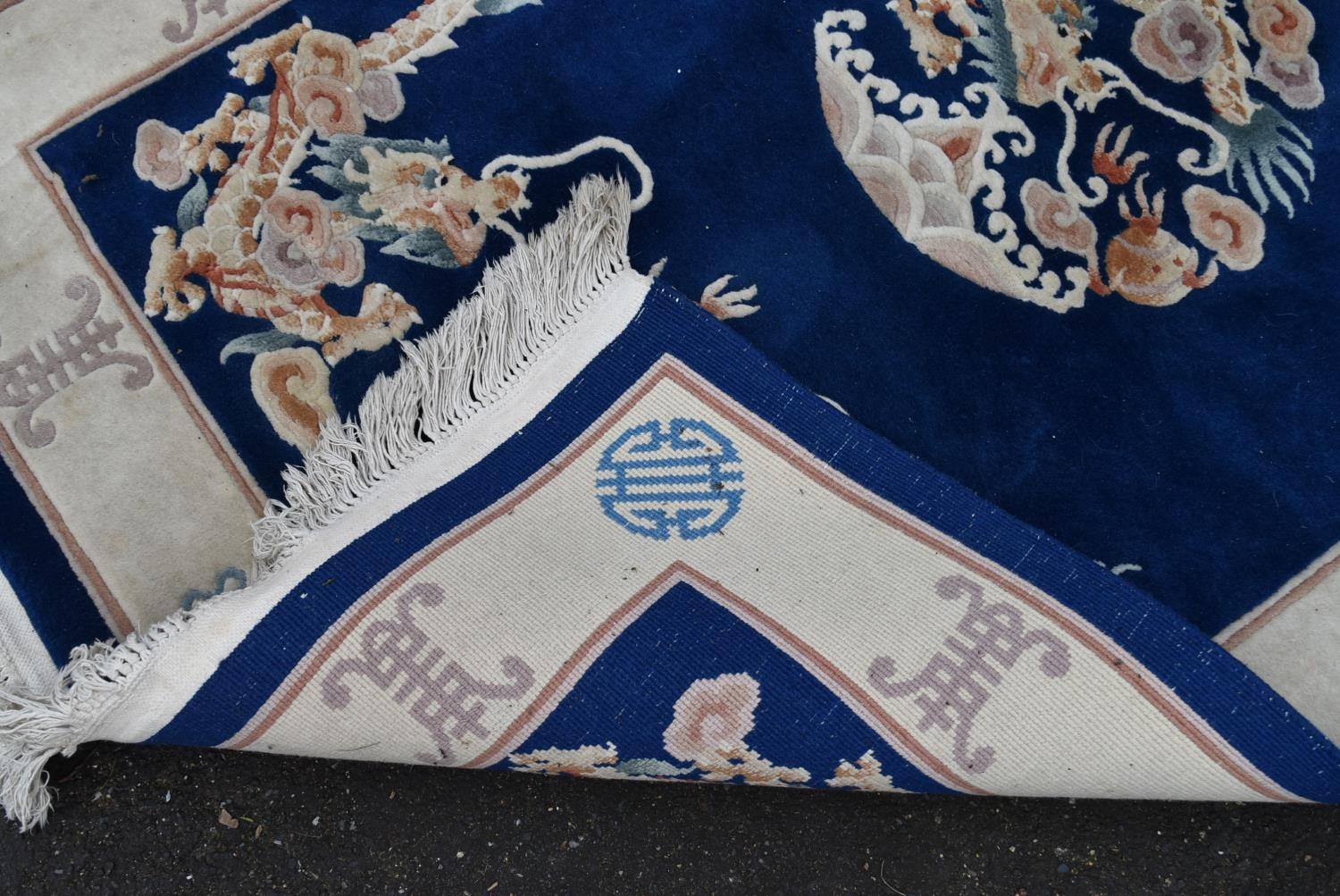 A Chinese rug with central floral medallion and dragon spandrels on a sapphire field surrounded with - Image 3 of 4