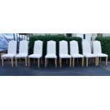 A set of eight high back calico upholstered dining chairs with fitted floral damask loose covers.