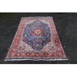 A Persian Keshan carpet with central floral medallion on sapphire ground within foliate multiple