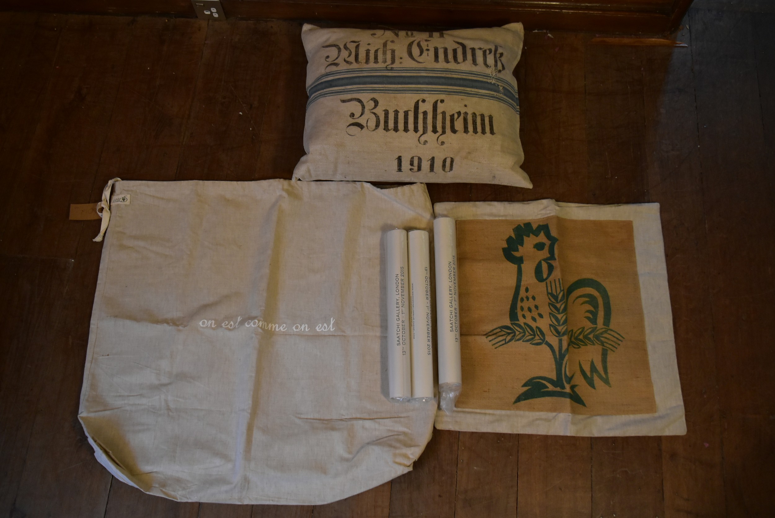 A cushion, canvas sacks and three Chanel posters. H.47 W.60cm (2)