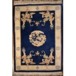 A Chinese rug with dragon medallion and spandrels on a sapphire ground within fawn border with