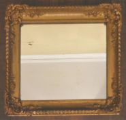 A 19th century giltwood and gesso wall mirror in scrolling floral frame with original plate. H.55