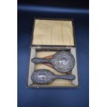 A sterling silver W Broadway & Co repousse work cased brush & comb set with stylised floral and