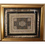 A gilt framed and glazed Persian silk rug on a black background with floral boarders. H.80 W.94cm