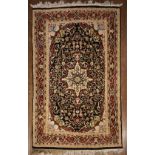 An Indian Agra silk rug with central floral medallion on midnight ground within naturalistic foliate