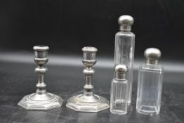 A set of three dressing table bottles with silver plated tops along with a pair of silver plated