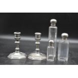 A set of three dressing table bottles with silver plated tops along with a pair of silver plated