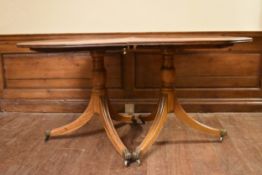 A Georgian style mahogany crossbanded and satinwood strung dining table on twin pillar supports,
