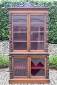 A mid 19th century oak two section library bookcase with glazed panel doors enclosing shelves