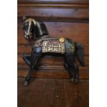 A hand painted polychrome carved figure of a horse. H.64 W.68cm (damage to one ear and hoof as