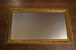 A 19th century gilt framed wall mirror with original plate in floral gesso decorated frame. H.134