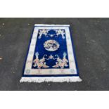 A Chinese rug with central floral medallion and dragon spandrels on a sapphire field surrounded with