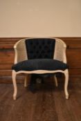 A French style painted tub chair with caned and buttoned back on carved cabriole supports. H.75 W.65