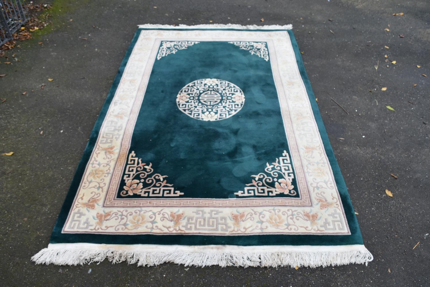 A Chinese carpet with emerald ground, central medallion within a cream foliate border. L.300 W.183cm