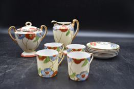 An Art Deco coffee set with hand painted foliate design, including four cups, six saucers, milk