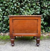 A 19th century mahogany commode with hinged top, fitted with lid and liner on turned tapering