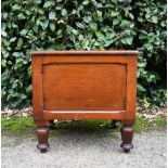 A 19th century mahogany commode with hinged top, fitted with lid and liner on turned tapering