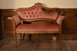 A walnut framed Rococo carved small canape in deep buttoned upholstery on cabriole supports. H.89