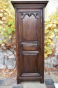 A 19th century French Provincial oak hall armoire with stepped pediment above carved panel door