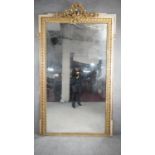 A 19th century giltwood and gesso tall pier mirror with flowerhead and ribbon cresting and