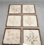 A set of six teak framed and glazed table place mats with floral decoration. H.39 W.41
