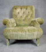 A contemporary Victorian style roll arm easy chair in deep, purple floral buttoned upholstery on