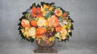 A cut out wooden screen with easel back, with decoupage flowers in a painted urn. Signed A.