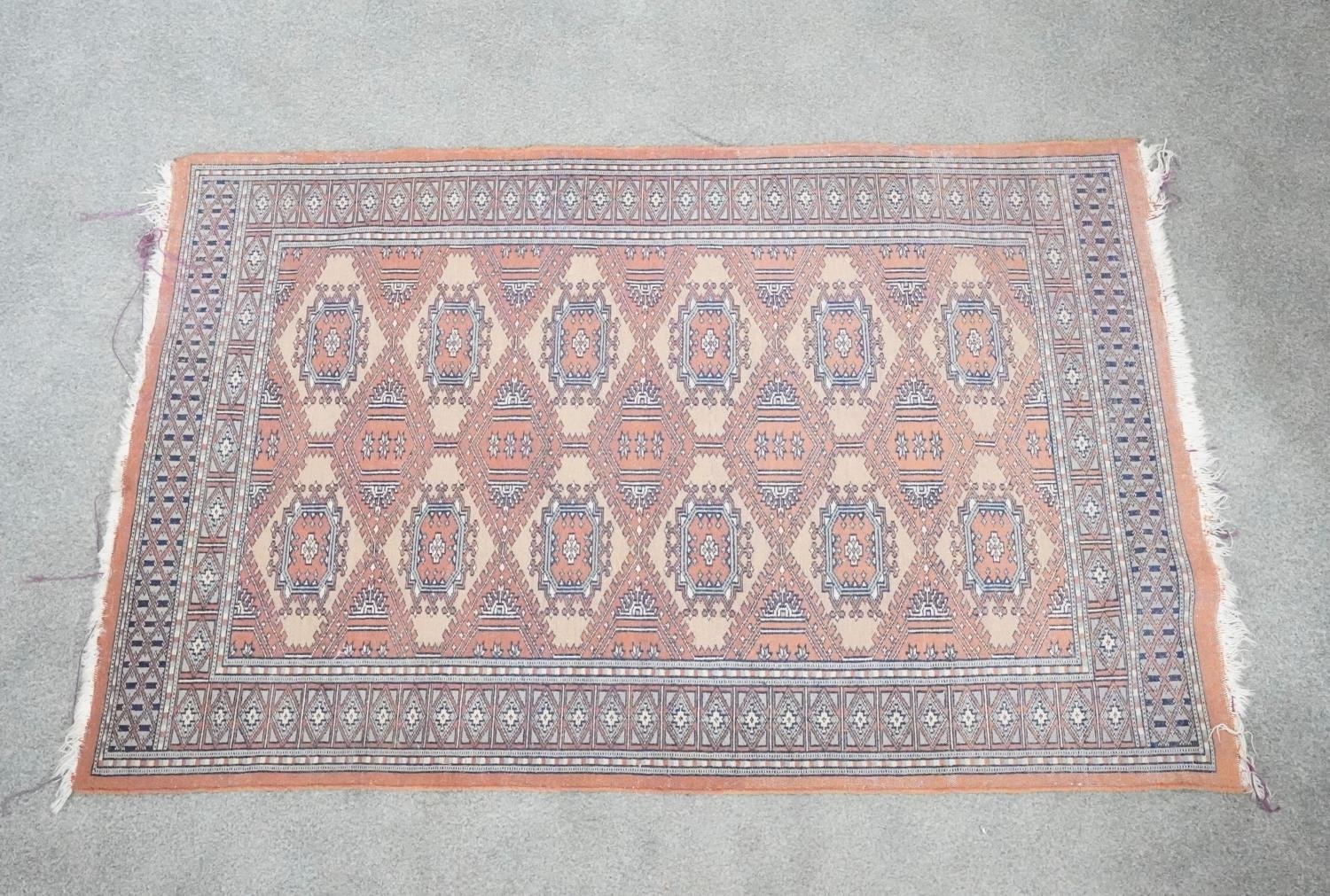 A Pakistan Bokhara rug with fawn ground and pendant motifs within a stylised border. H.91 W.150