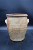 A stoneware twin handled pot with bread board lid. H.29 W.25cm