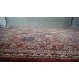 A red ground Bakhtiar carpet with garden motifs in floral borders. H.234 W.250