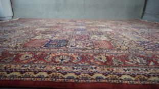 A red ground Bakhtiar carpet with garden motifs in floral borders. H.234 W.250