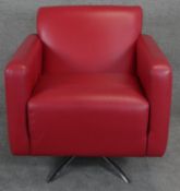 A retro vintage design swivel armchair in red leather upholstery on chrome supports. H.85cm