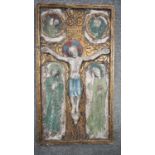 An early 20th century ceramic relief plaque of the Crucifixion with painted and gilded details. H.59