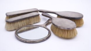 A sterling silver five piece brush and mirror set. Each of the pieces with engine engraved