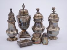 A collection of silver salt/pepper and mustard pots and shakers along with silver miniatures. Pair