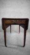 An early 19th century mahogany drop flap Pembroke table fitted with frieze drawer on square tapering