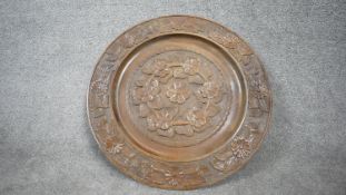 A large carved Black Forest hardwood plate with relief floral and foliate design. D.58